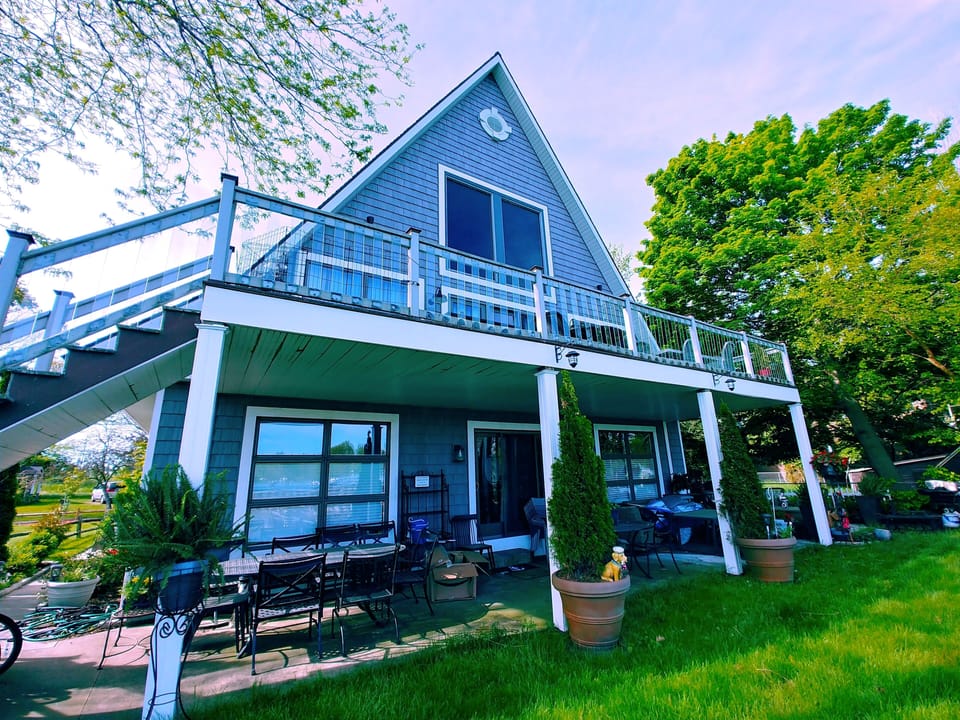 Large deck and covered patio facing the channel with ample outdoor seating.