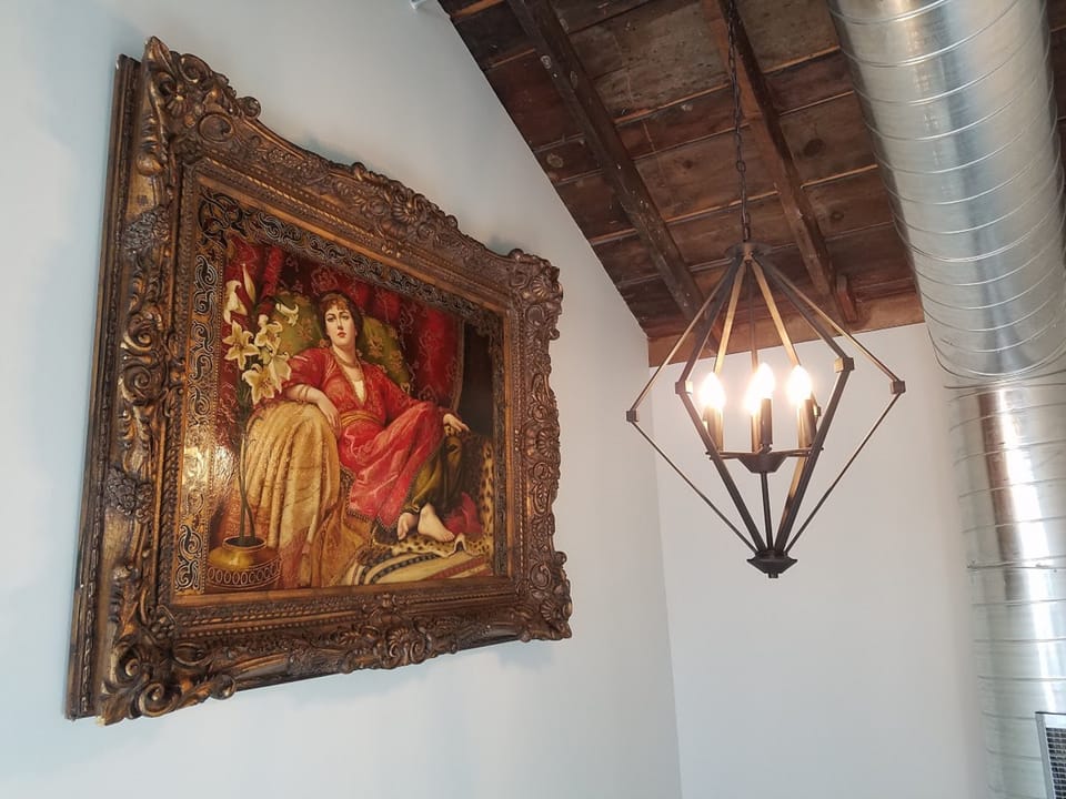 Stunning oil painting in the industrial designed foyer leading upstairs