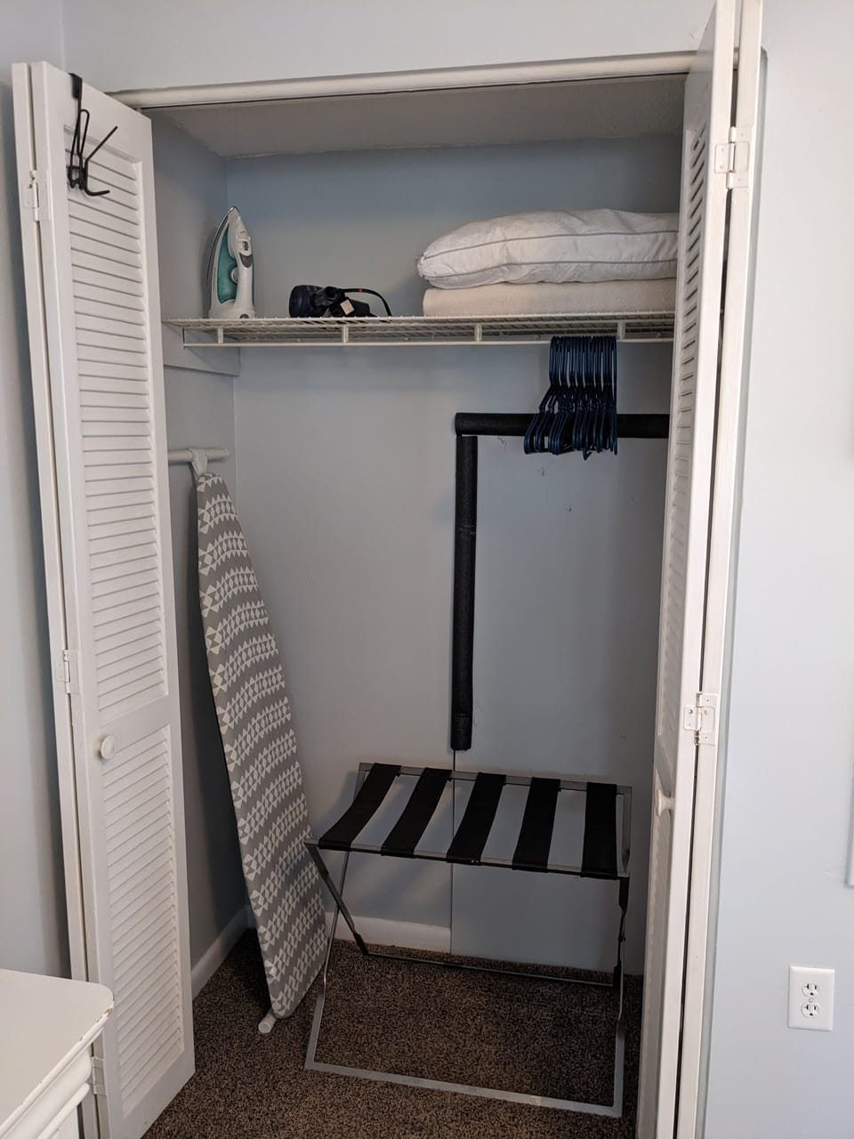 Master Queen bedroom closet with extra pillows, blankets, iron, ironing board.