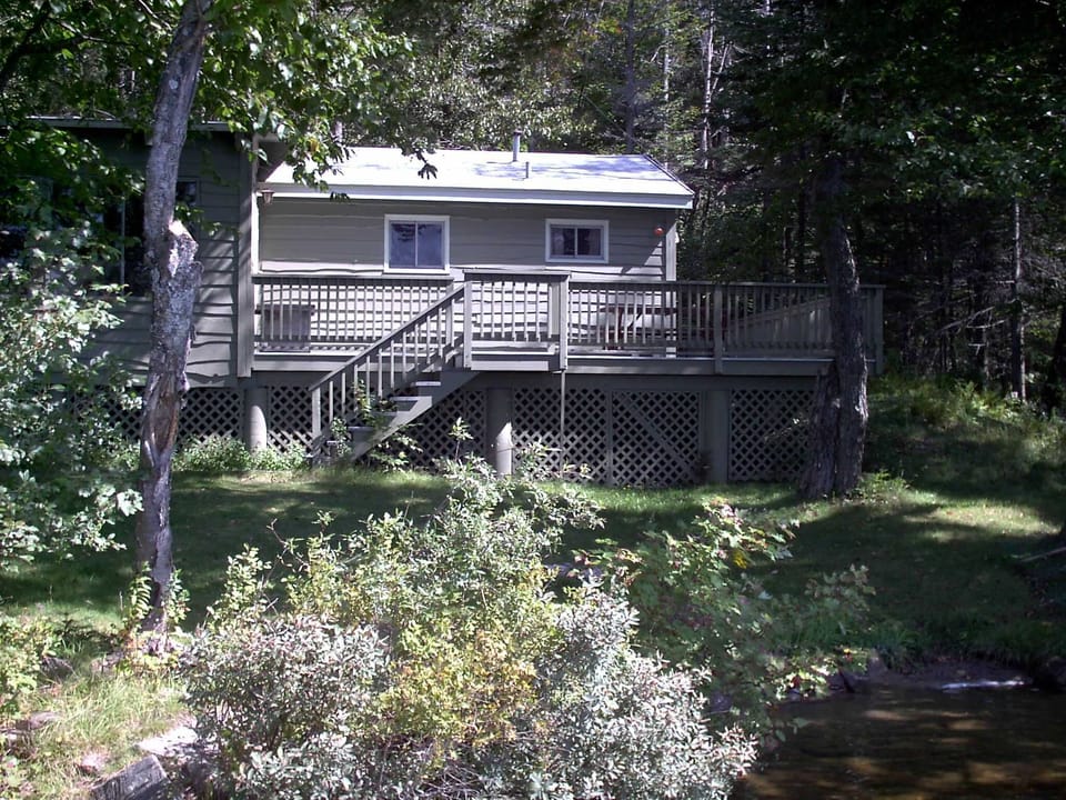 Cottage with gently sloping lawn leads to private beach area & easy access to crystal clear lake