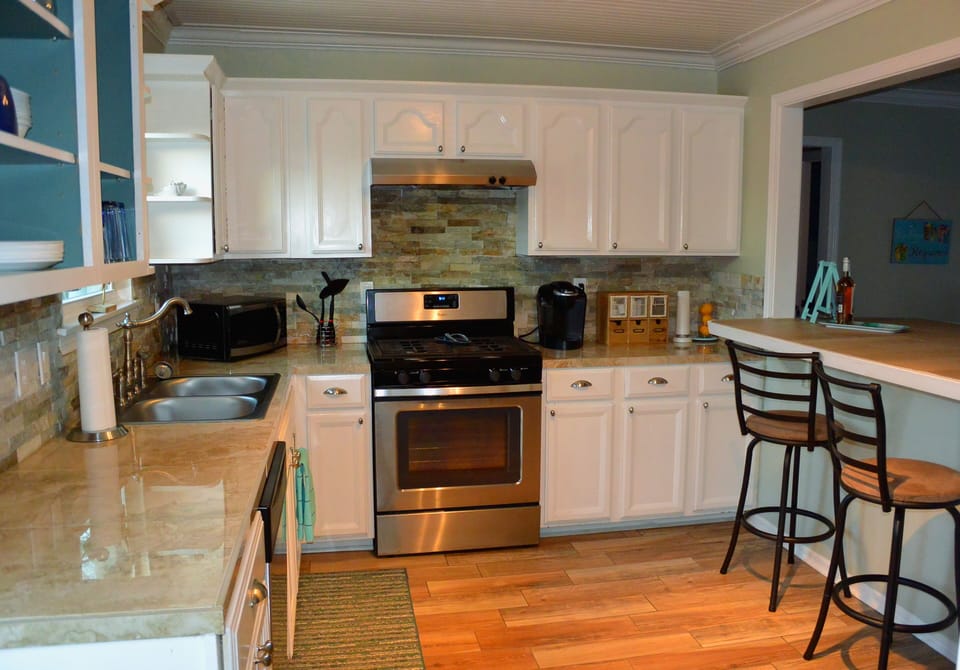 Updated kitchen overlooks living room and features a Keurig coffee maker.
