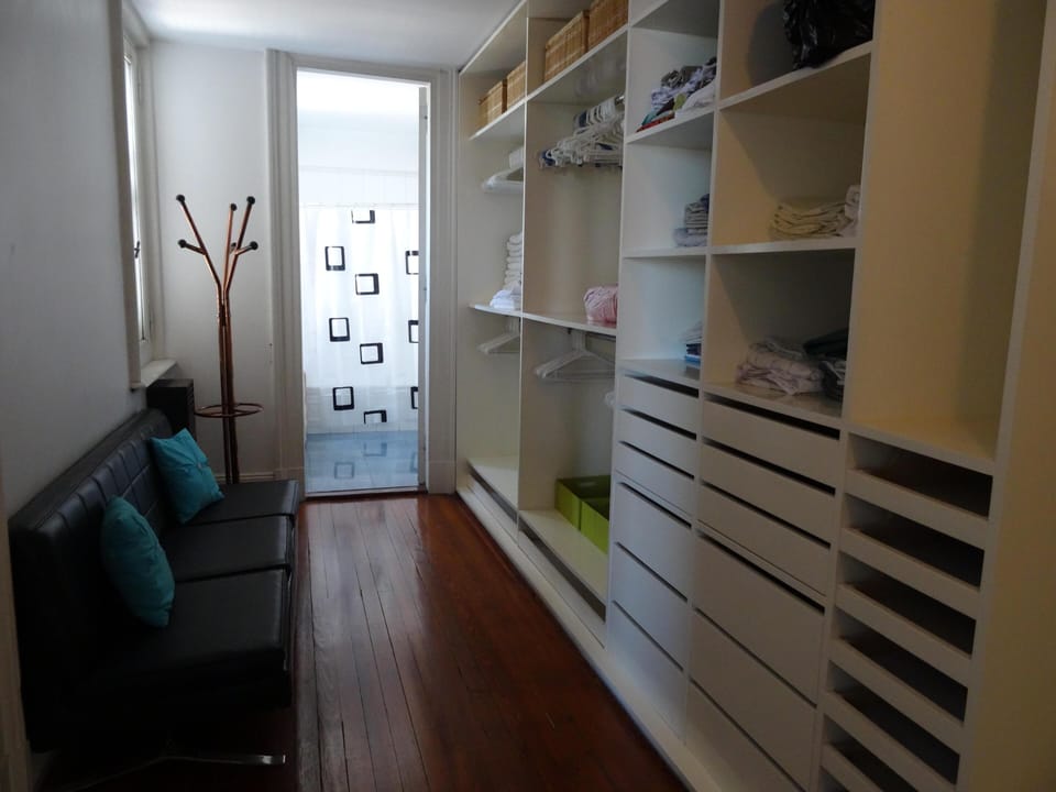 large built in closet and dressing area with couch next to the master bedroom