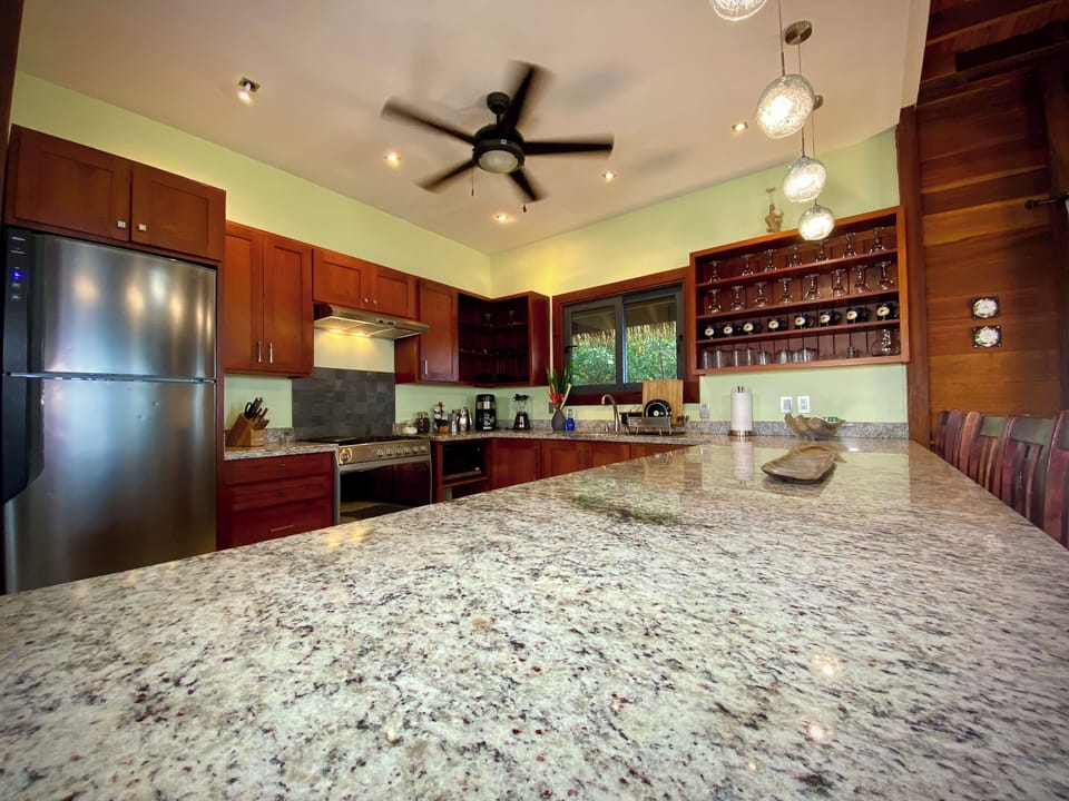 Large open plan kitchen with granite countertops and stainless steel appliances.