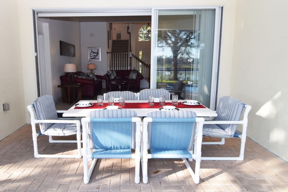 Beautiful south-facing pool deck with lake views, loungers, dining area