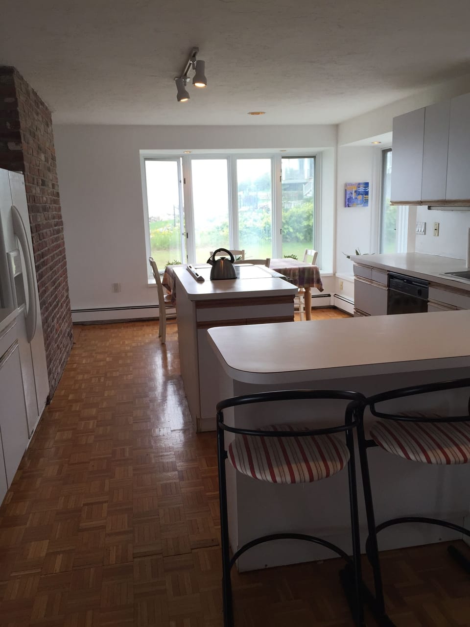 Kitchen has dining area, counter stools, dishwasher and opens to living areas