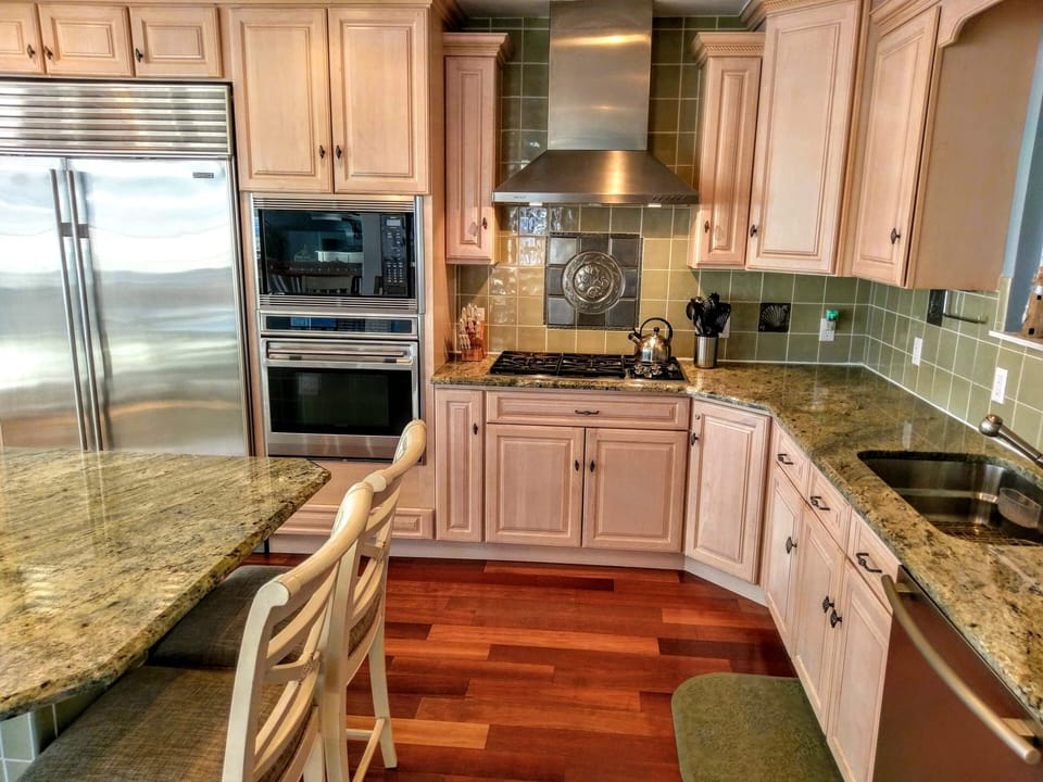 kitchen with double oven, dishwasher, cook top with hood