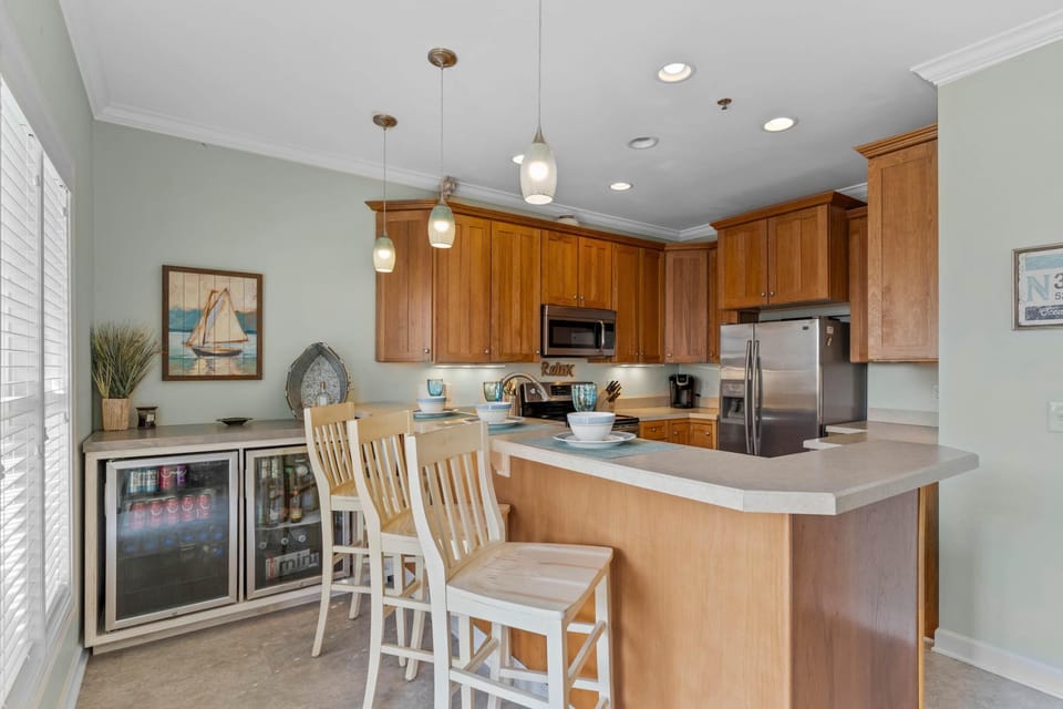 full kitchen with bar seating, beverage/wine cooler and dining area