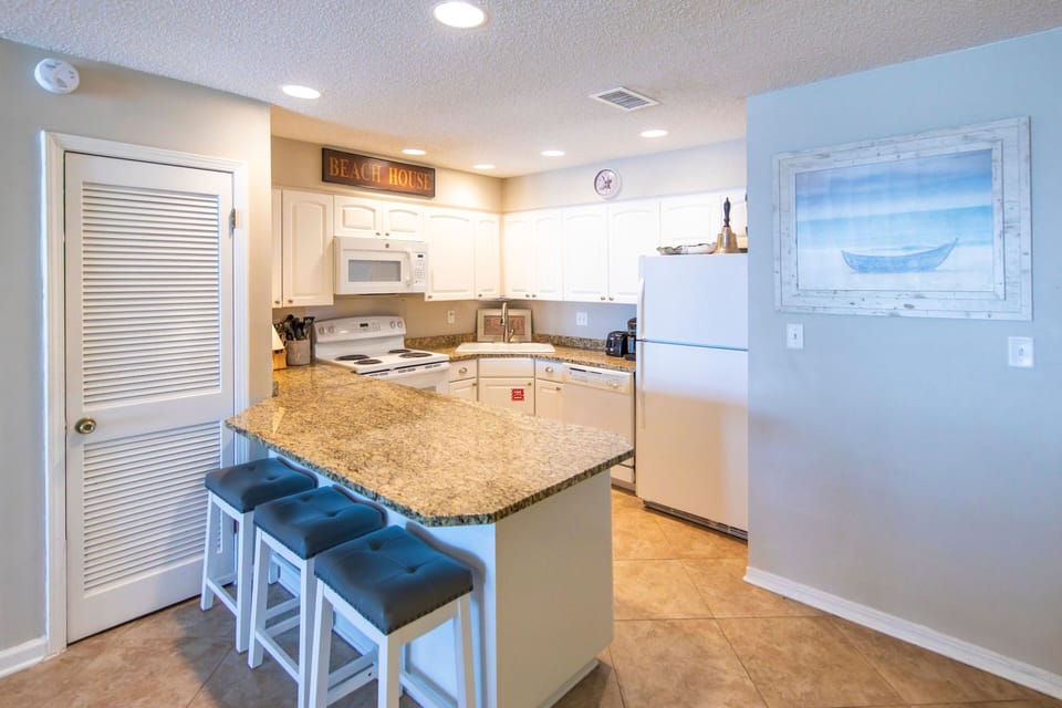 Kitchen with counter and 3 bar stools. Wonderful Gulf views