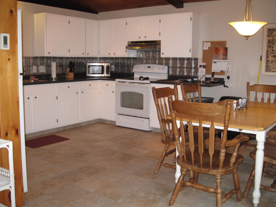 Fully equipped kitchen with Jenn-Air grill, large windows, and deck access.