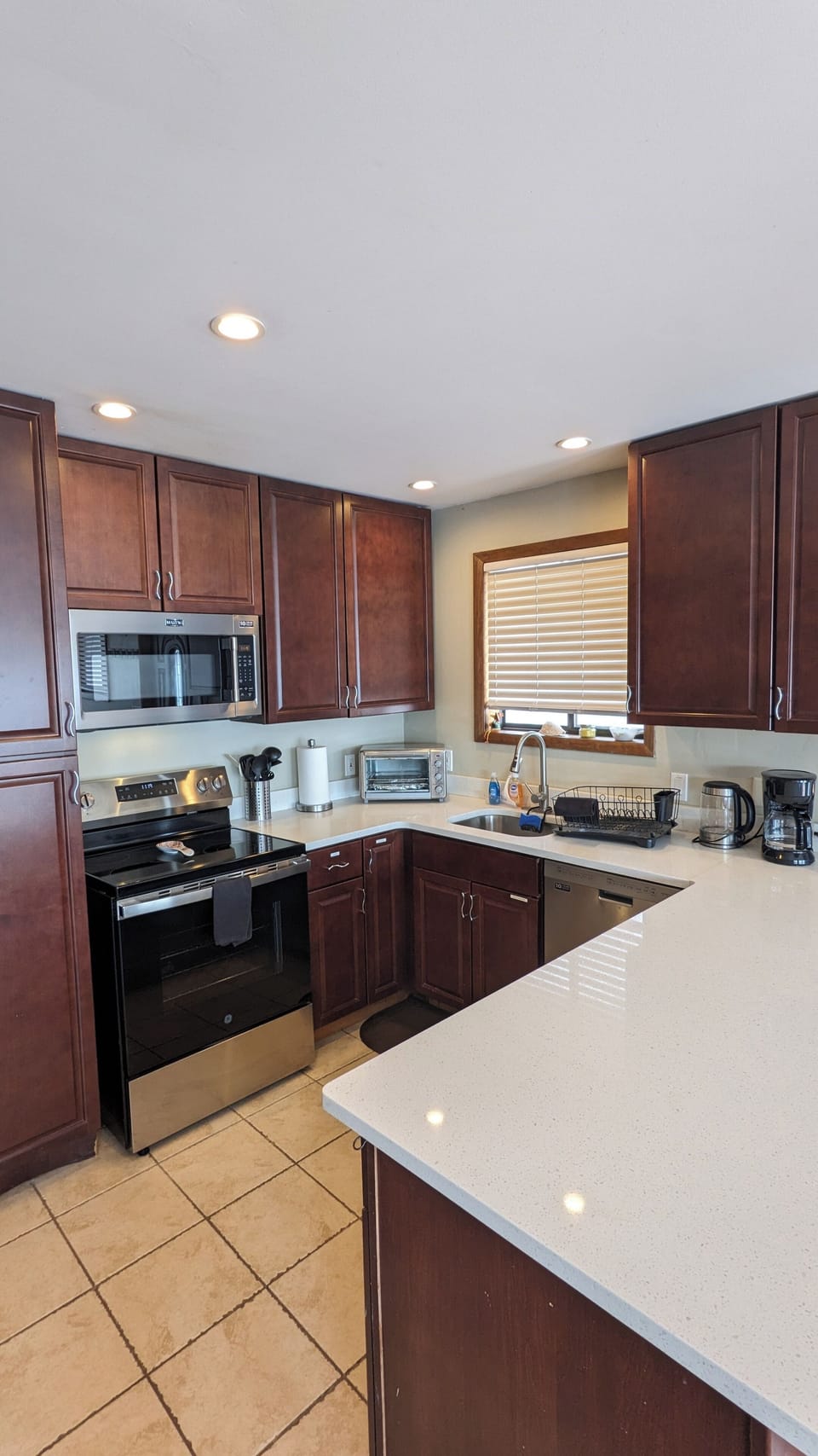 Fully stocked kitchen with stainless steel stovetop, oven, microwave, dishwasher