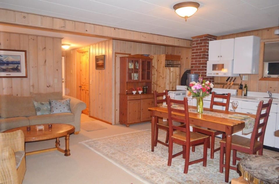 Knotty pine is cozy in open dining and living room with full kitchen