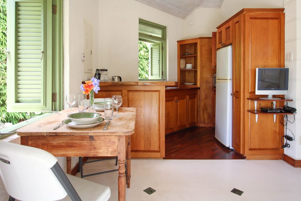 A wooden table full of character is set up by the window - perfect for casual meals