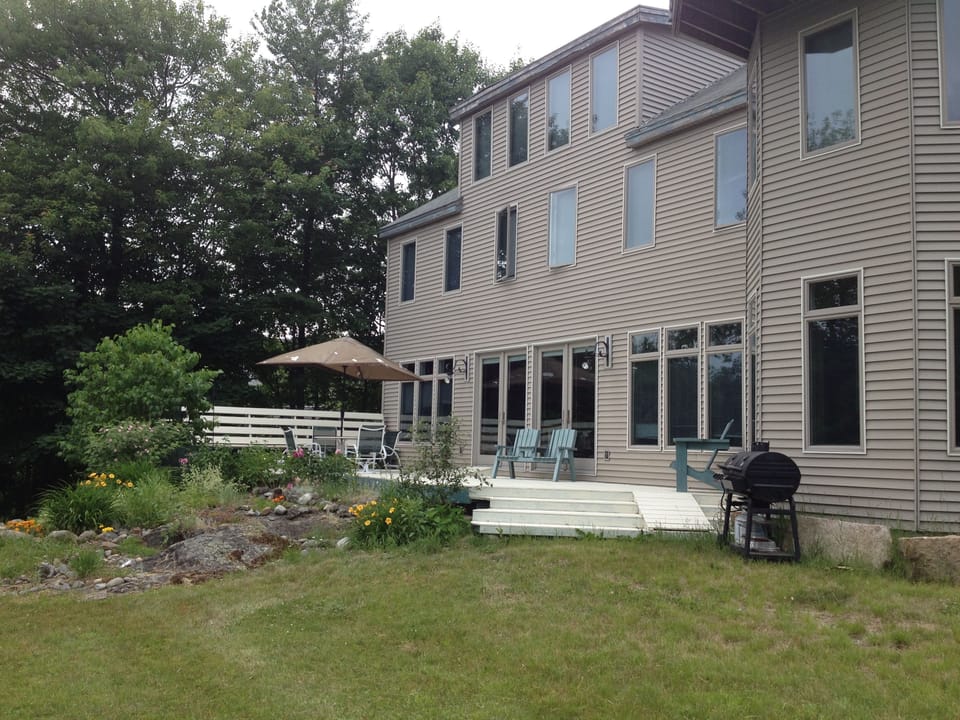 Deck has bench seats, umbrella table, picnic table, gas grill.