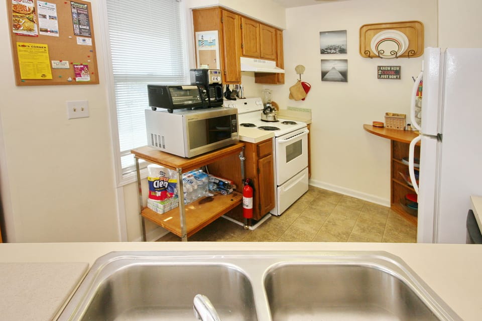 Fully stocked kitchen with dishes, cookware, microwave, coffee maker, oven, etc