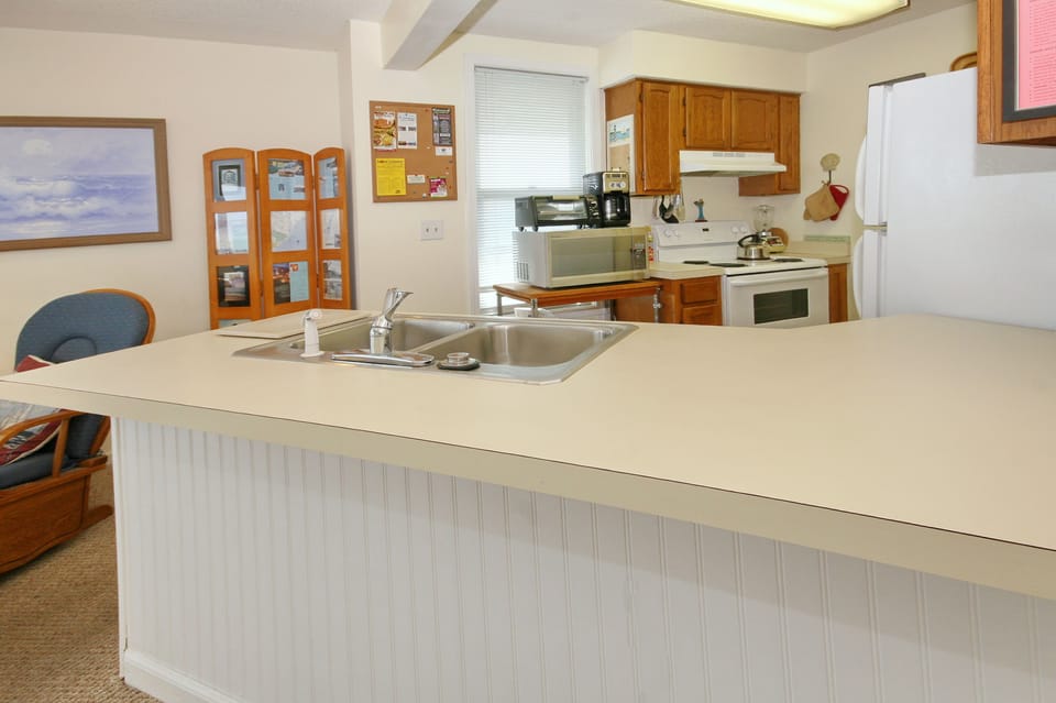 Fully stocked kitchen with dishes, cookware, microwave, coffee maker, oven, etc