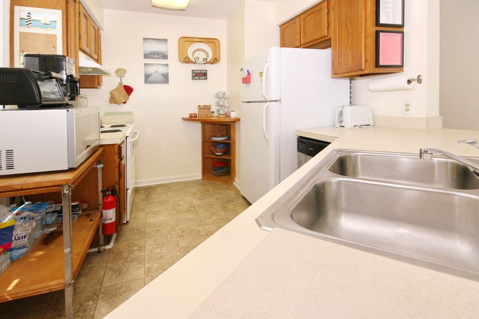Fully stocked kitchen with dishes, cookware, microwave, coffee maker, oven, etc