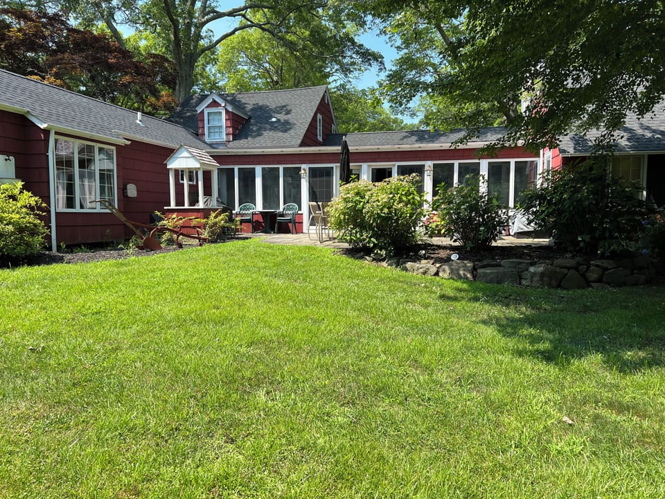 large yard with slate patio surrounded by an English garden