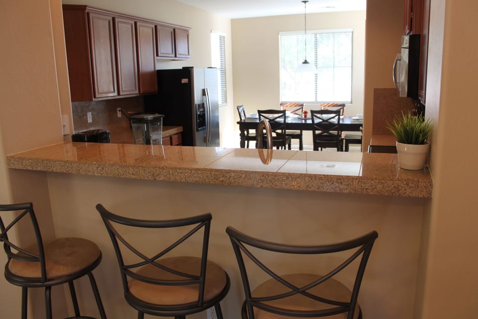 Bar stools with a view into the kitchen area.