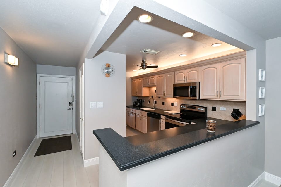 Modern, renovated, fully equipped kitchen with composite counters, tile back splash...