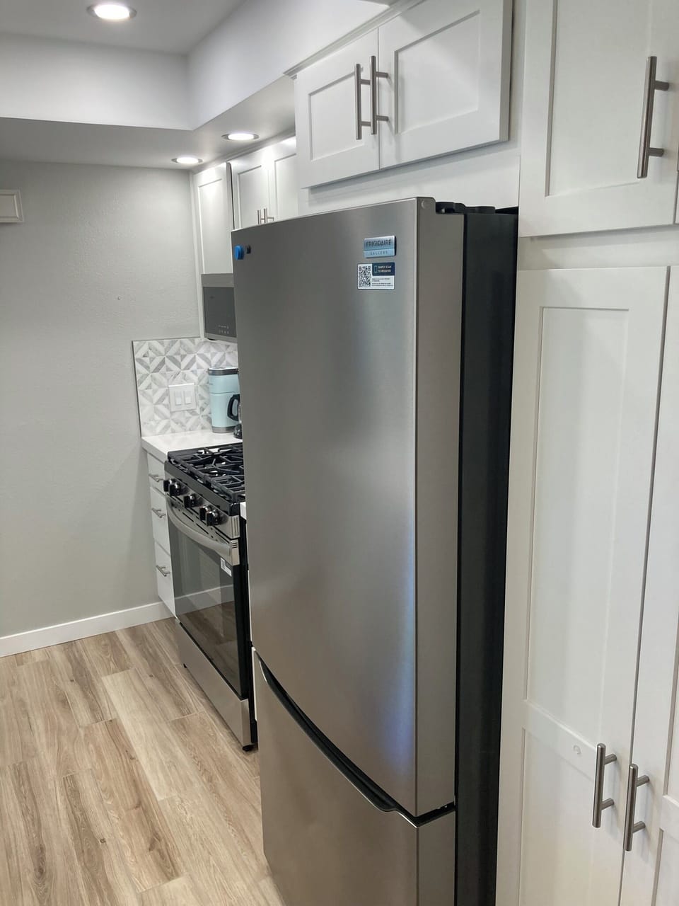 Empty roller drawer pantry for your groceries, new refrigerator and stove.