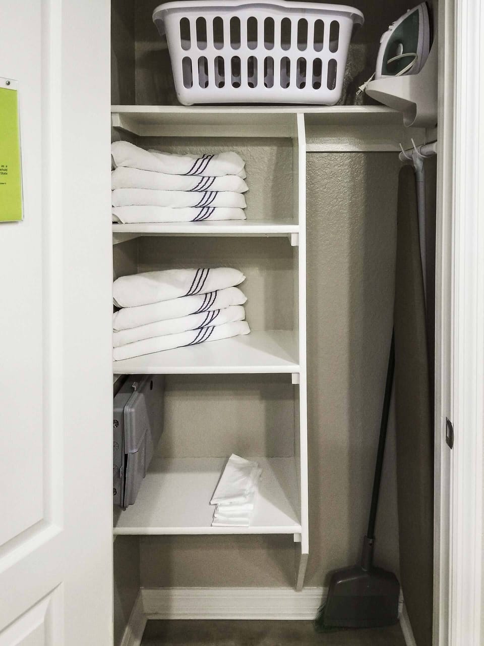 Utility closet with Towels, Laundry basket, Iron and Ironing board.