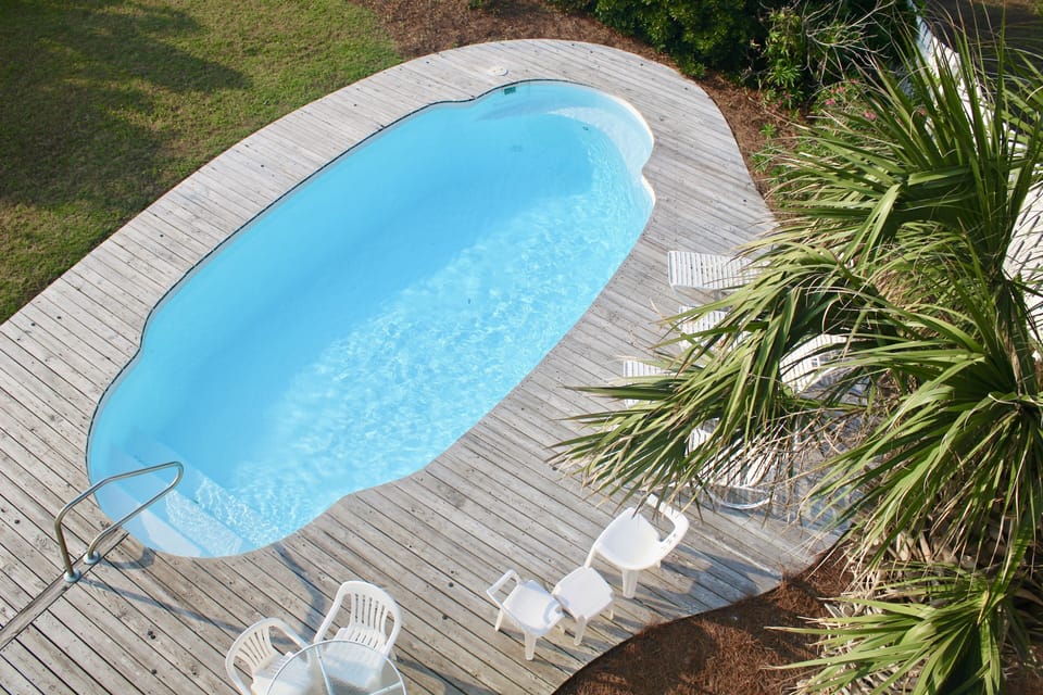 Private fenced-in swimming pool with lounge chairs