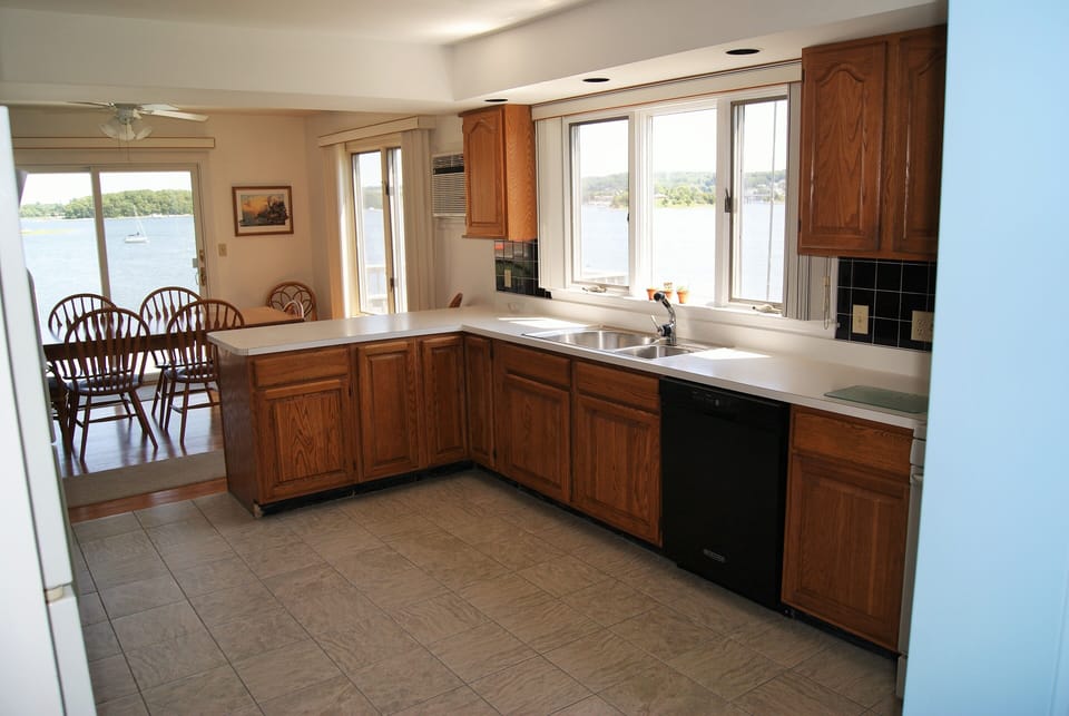 Kitchen to dining area from front door. New tile floor. New paint. D/W right.