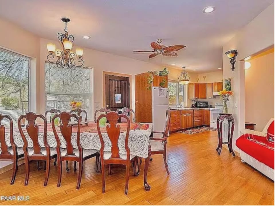 The dining area is tucked into a bay window with front door and kitchen beyond. 