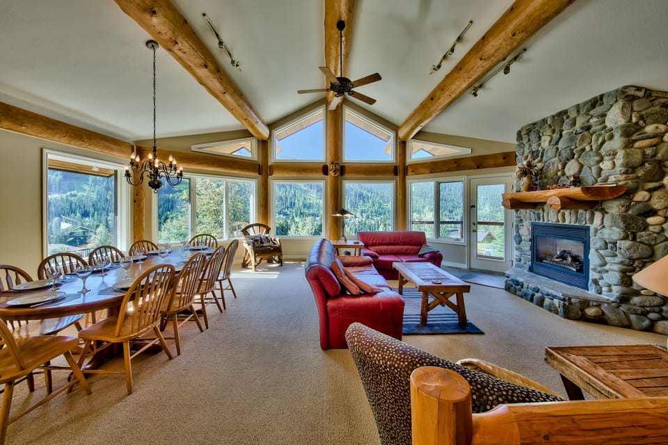 Large living area with dining table, panoramic views and river rock fireplace. 
