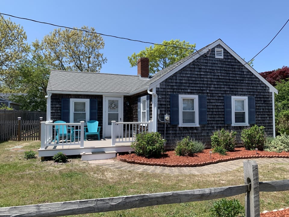 Front of house with new deck and Adirondack chairs 