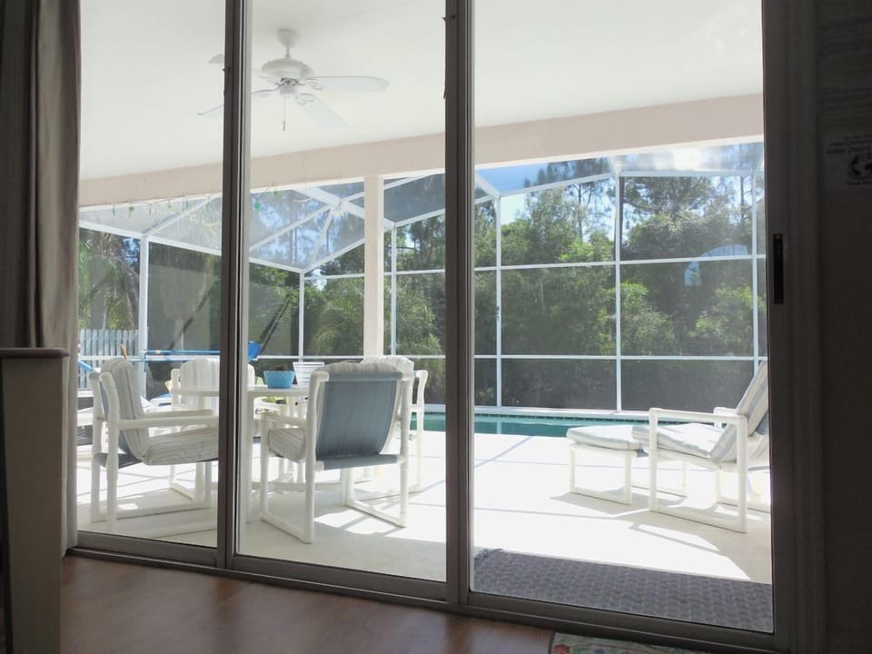 View to the pool deck and conservation from within the house