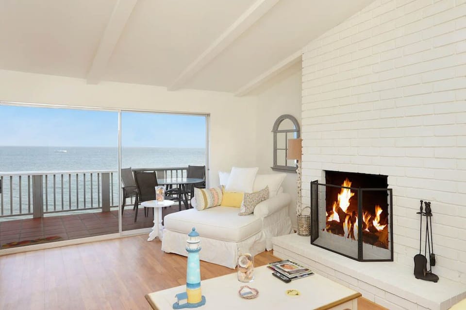 Luxurious living room with ocean views & wood burning fireplace