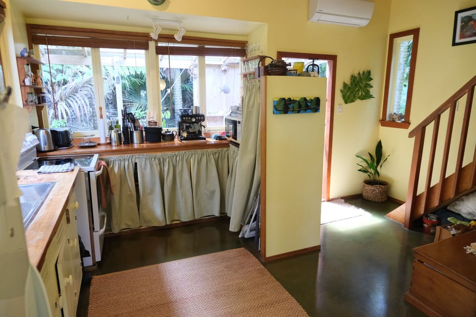 Kitchen area with stairs leading to bedroom on mezzanine floor.