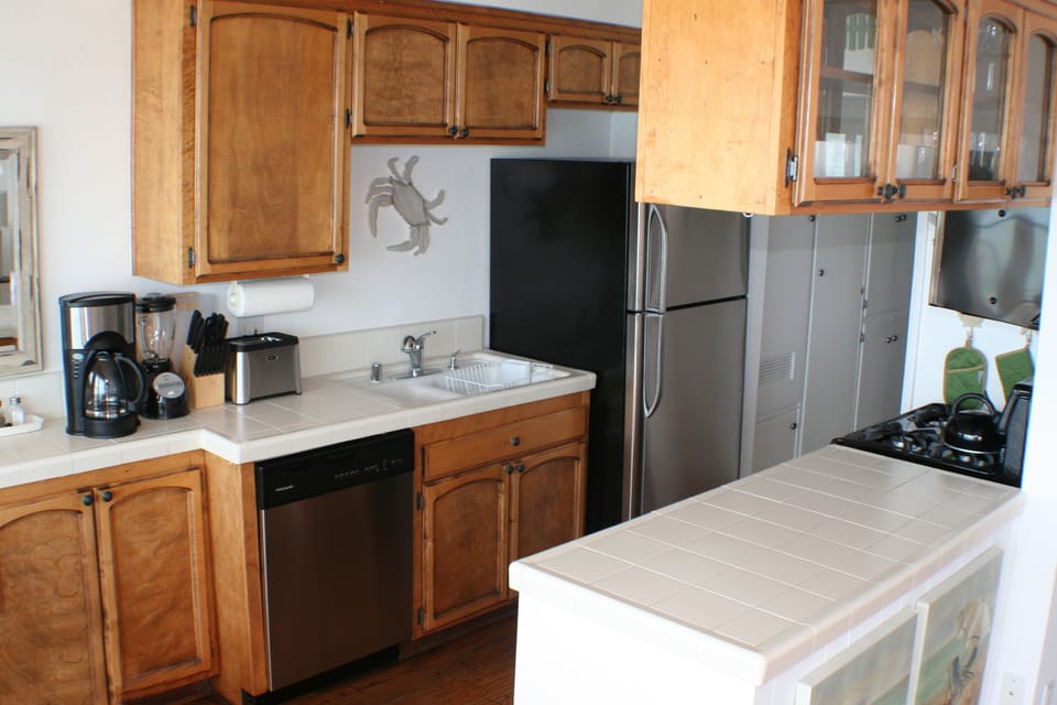 Fully equipped kitchen with stainless steel appliances including a dishwasher