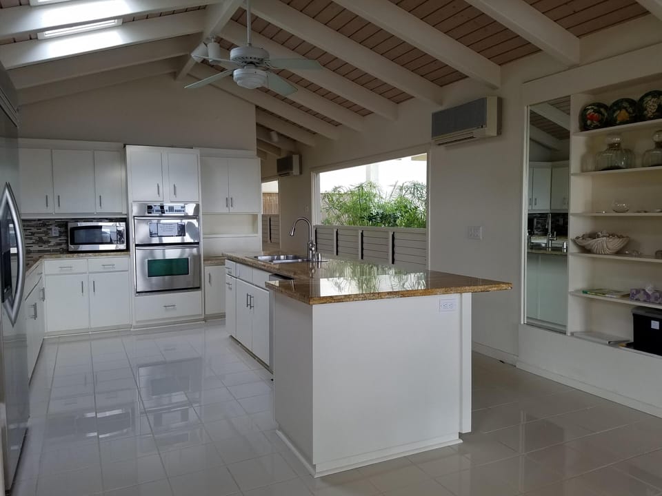 Kitchen with views of the atrium & wooden louvre windows for natural air flow