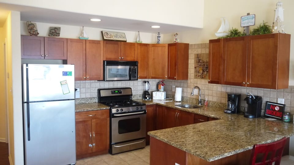 Stainless Kitchen, granite counters, tile floor and decorative art