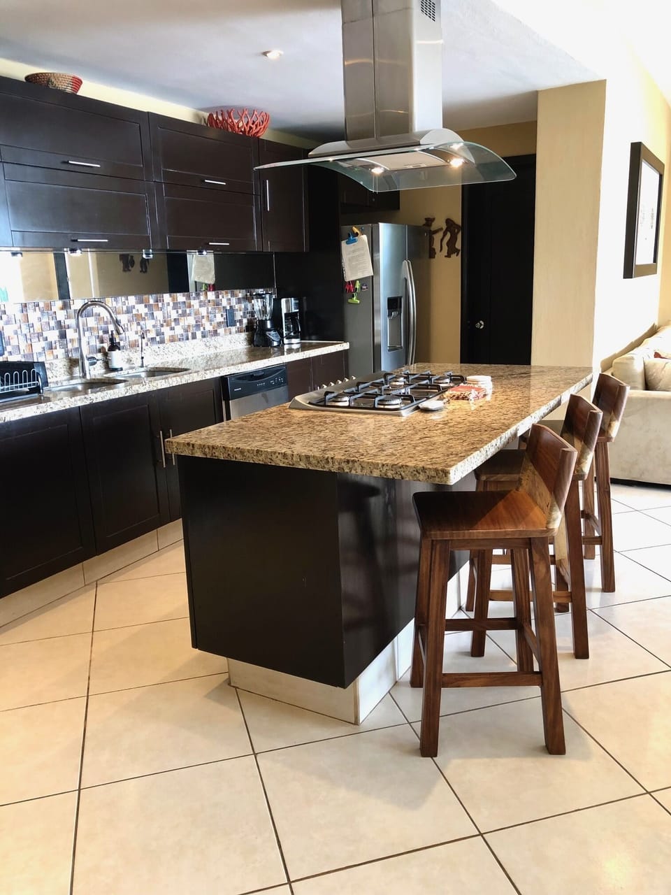 Well equipped kitchen with island bar stools