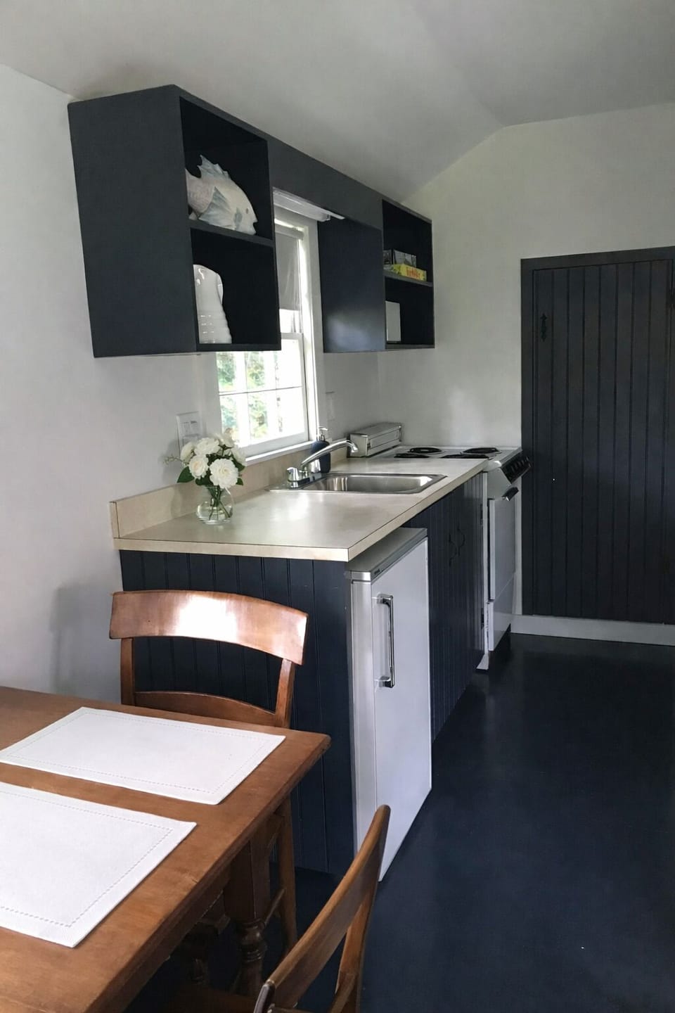 Kitchenette (with oven/stove/sink/mini-fridge) and dining area in apartment