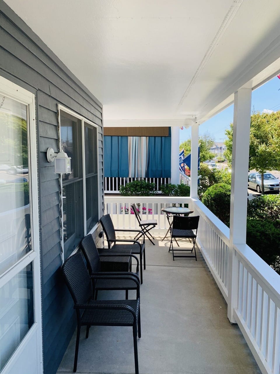 Front wrap around porch with seating and small table for two. 
