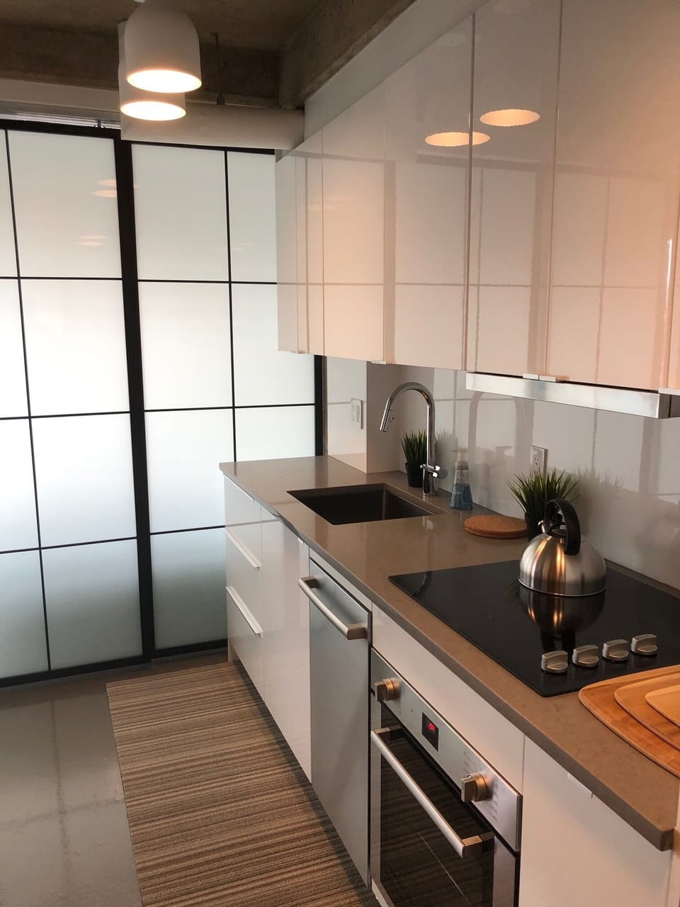 Sleek, quartz kitchen countertops and slding glass doors separates the bedroom.