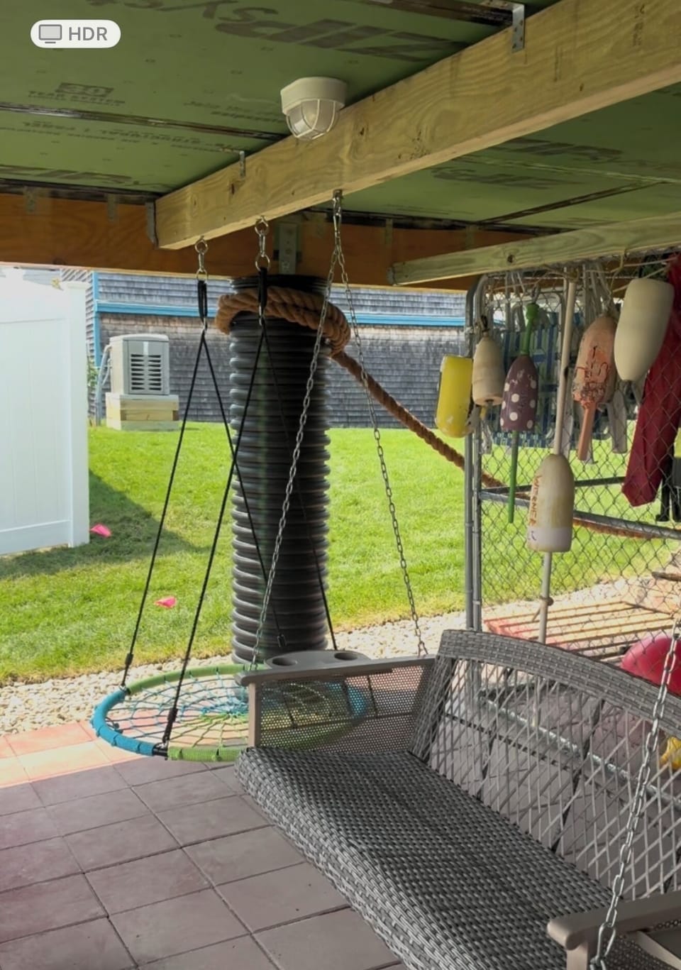 Covered patio area with swings and enclosed beach toy storage area