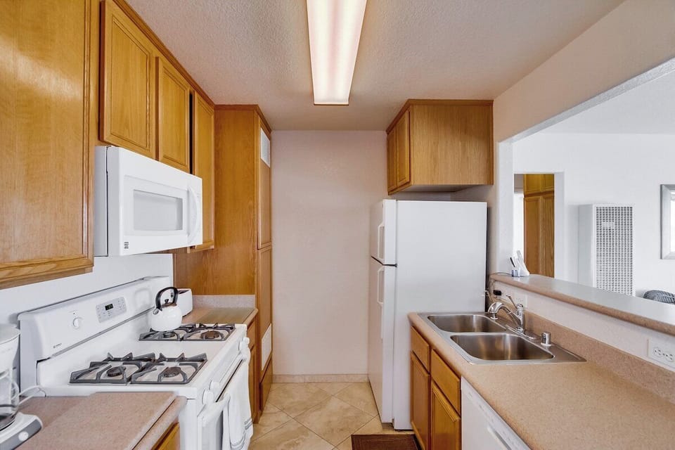 Kitchen with refrigerator, sink, gas stove, oven, microwave, toaster, blender, coffee pot, dishwasher