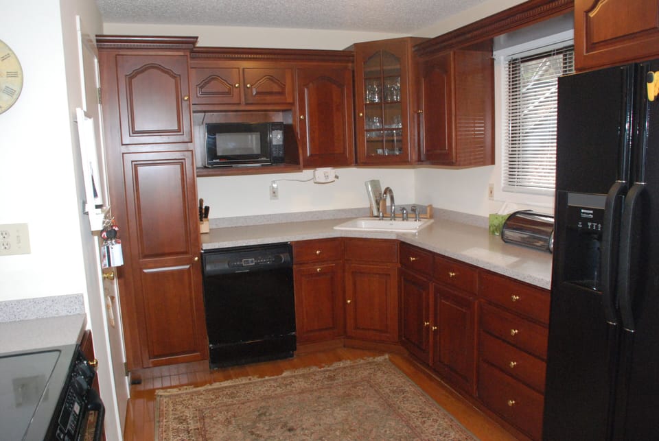 Cherry wood cabinets and updated appliances in kitchen