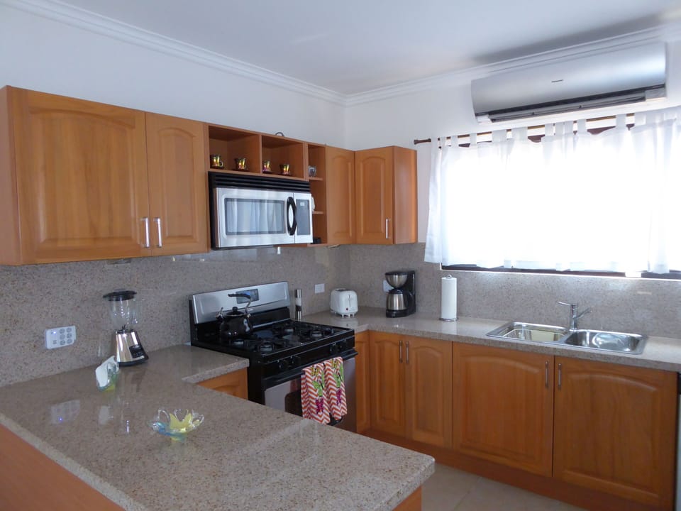 Bright, airy kitchen with granite countertops, coffee maker, and blender
