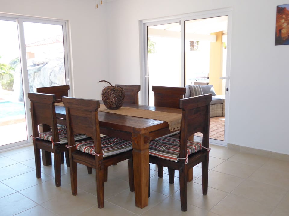 Dining room surrounded by sliding glass doors and a beautiful view of the pool 