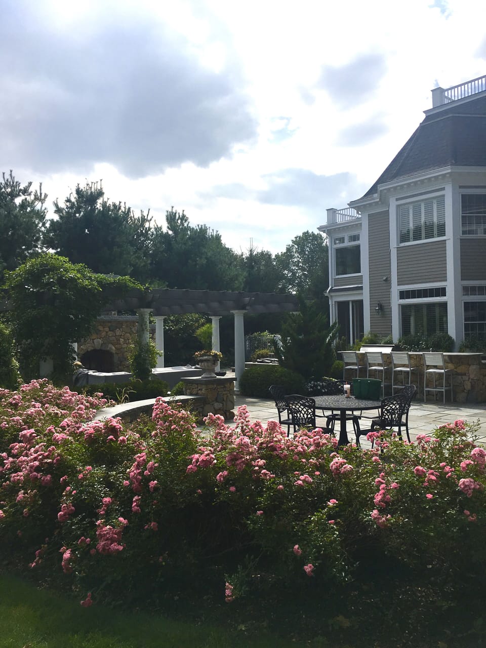 Outdoor dining with couch, tables, bar, fireplace
