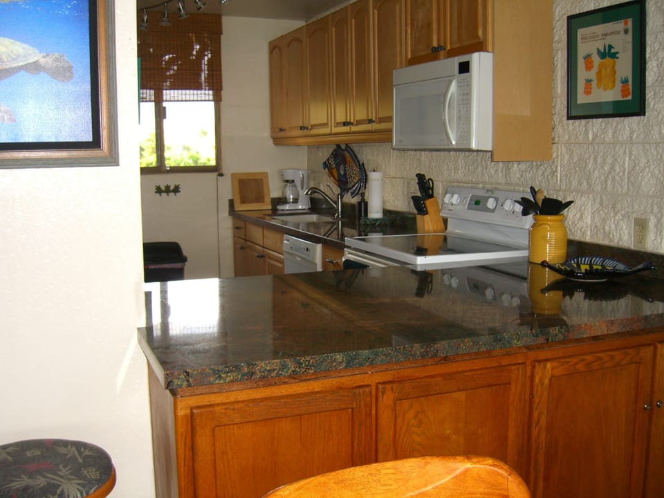 Bar and kitchen with granite counters.