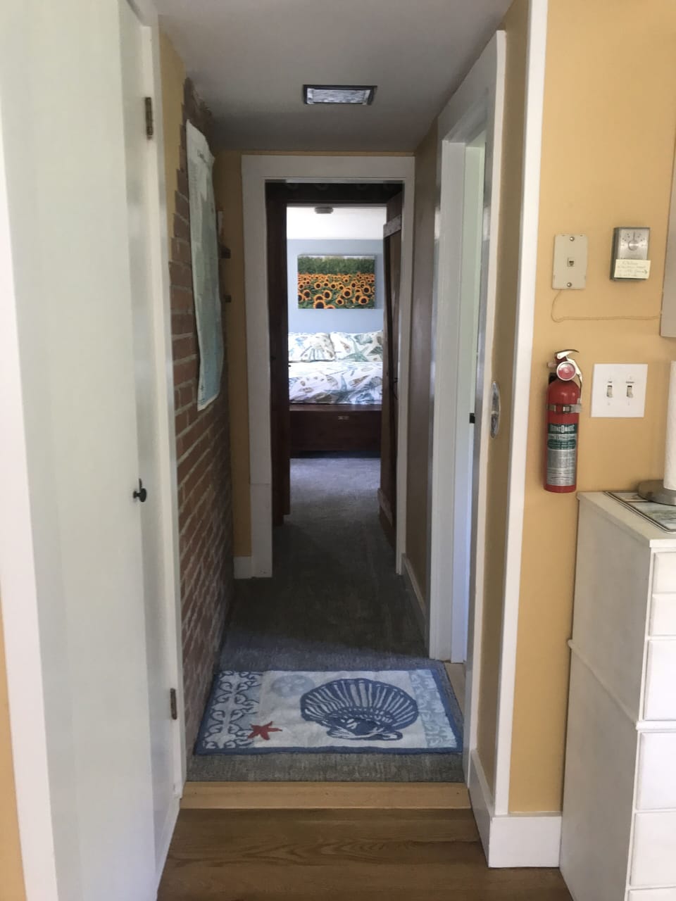 Hall between kitchen and bedroom with bath located off hallway