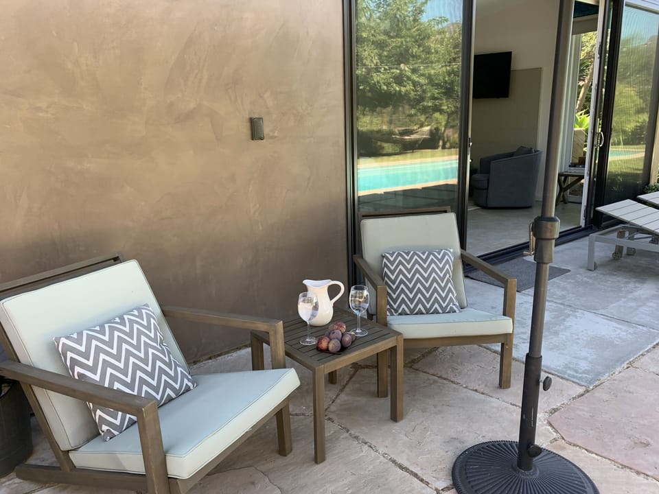 sitting area with a view of pool and garden