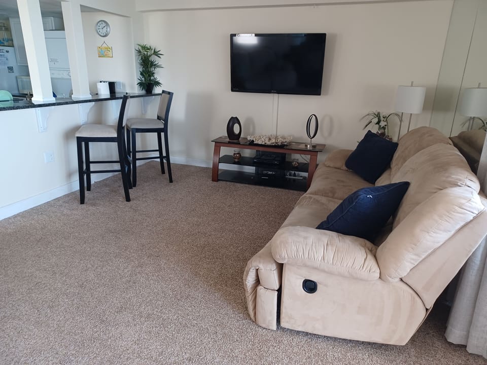 Living Room with 2 recliners, big screen TV many mirrors and perfect  ocean view